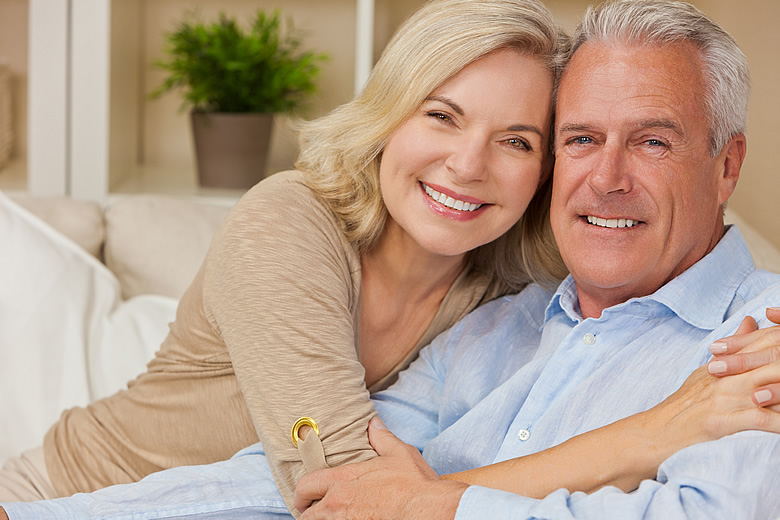 Smiling couple sitting in their living room